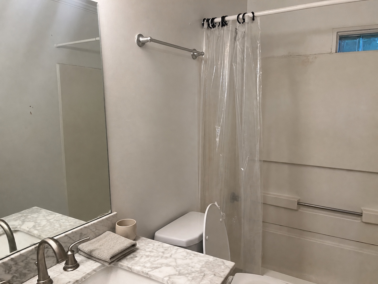 Full bathroom with marble-look vanity and tub-shower combo