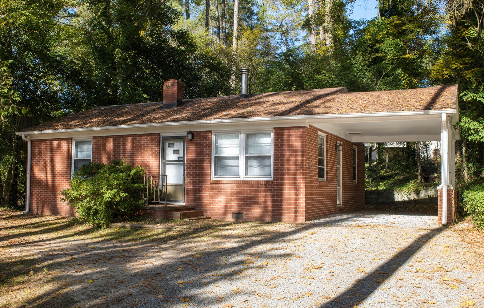 Brick ranch home with covered carport and gravel driveway at 202 Howell St
