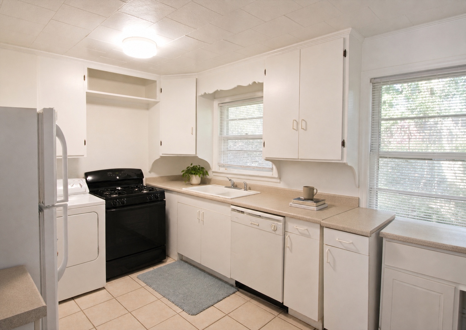 Kitchen with gas range, dishwasher, and windows overlooking the trees