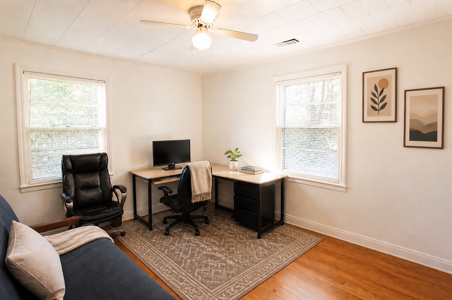 Second bedroom with hardwood floors and dual windows, shown as a home office