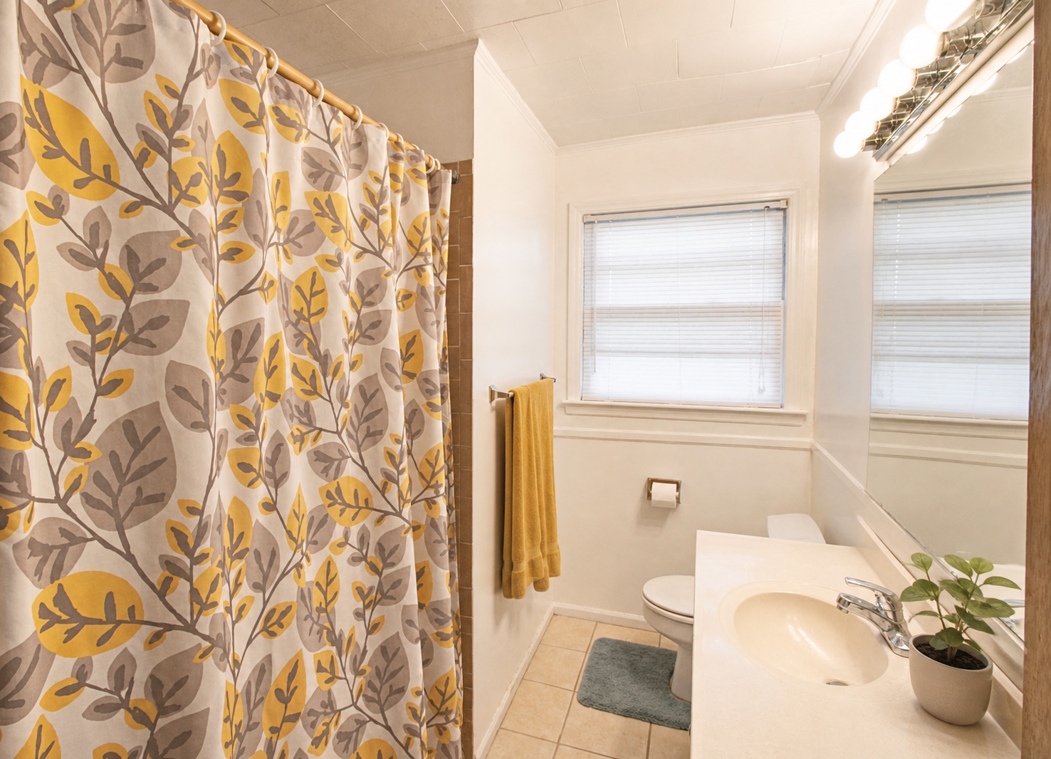 Full bathroom with tub-shower, vanity, and large mirror