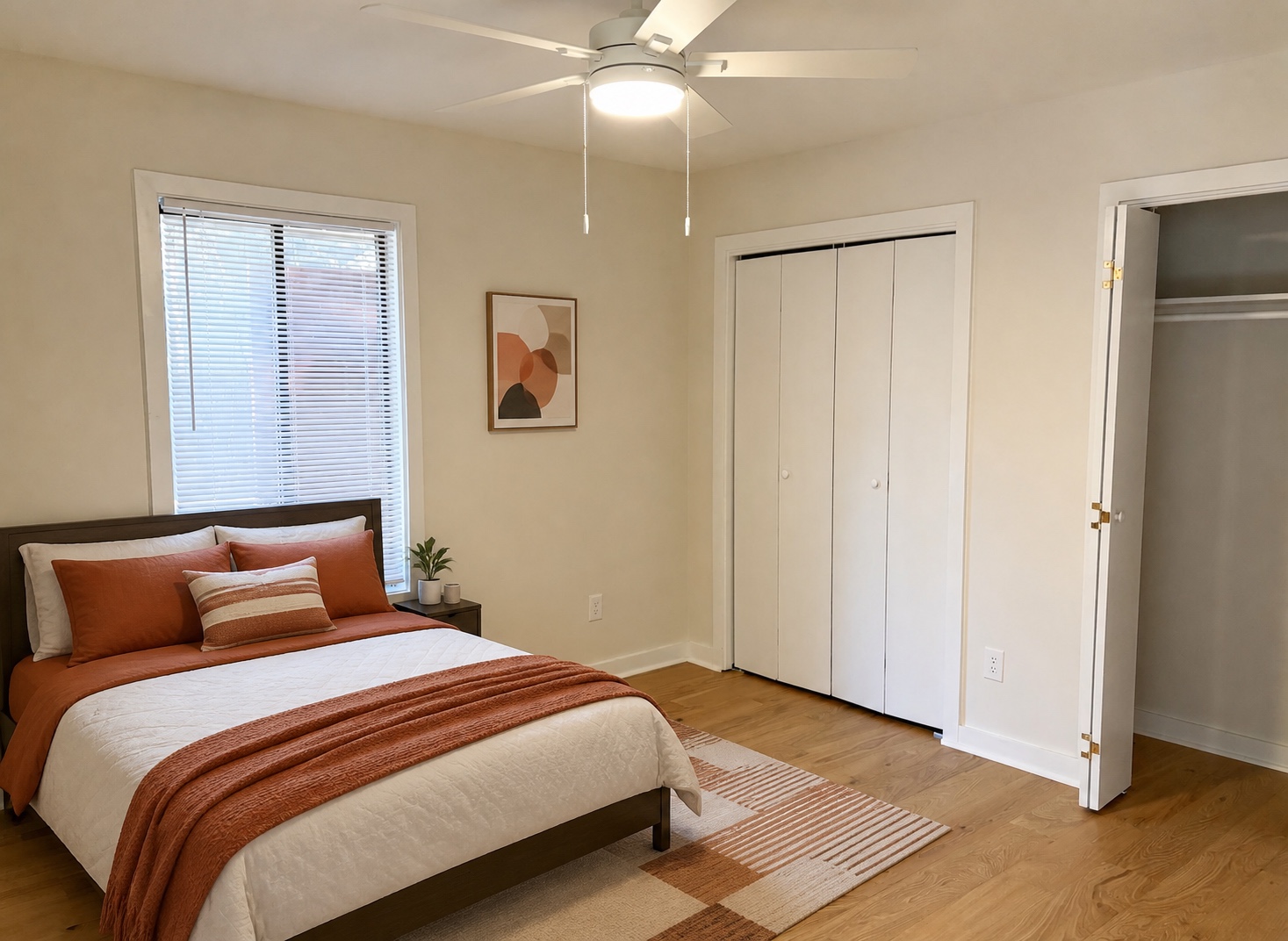 Second bedroom with hardwood floors, ceiling fan, and two closets (similar unit shown)